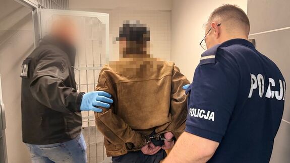 Policjanci wprowadzają zatrzymanych do komendy.