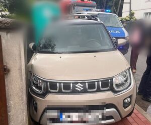 Rozbite BMW stoi przy ogrodzeniu, w które uderzyło, jest to drewniany płot, przy tym pojeździe stoi policjant. Na kolejnym zdjęciu widoczne jest suzuki, które zostało uszkodzone przez bmw