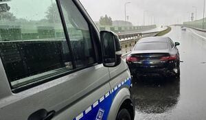rozbite samochody stojące na jezdni w tle radiowozy policyjne