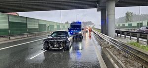 rozbite samochody stojące na jezdni w tle radiowozy policyjne