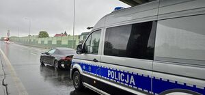 rozbite samochody stojące na jezdni w tle radiowozy policyjne