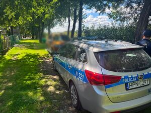 Policyjny radiowóz stoi przy jeziorze