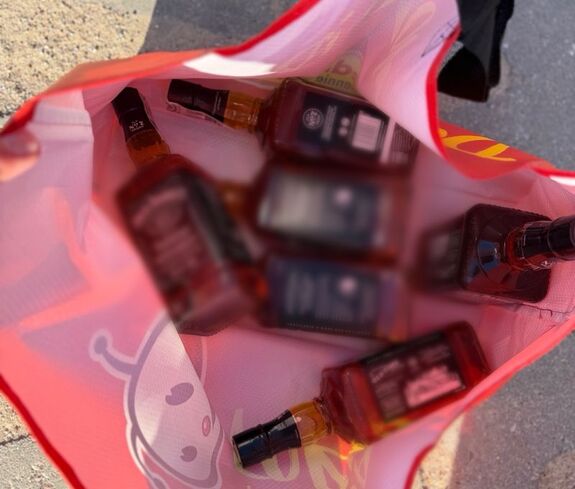 6 butelek whisky znajduje się w czerwonej torbie na zakupy