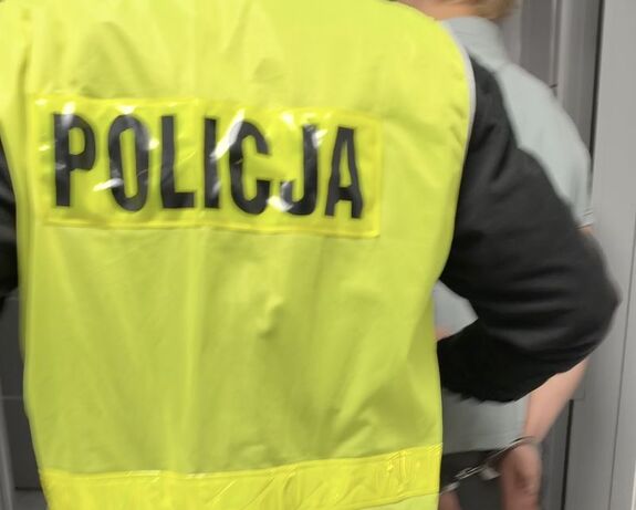 Policjanci prowadzą zatrzymanego