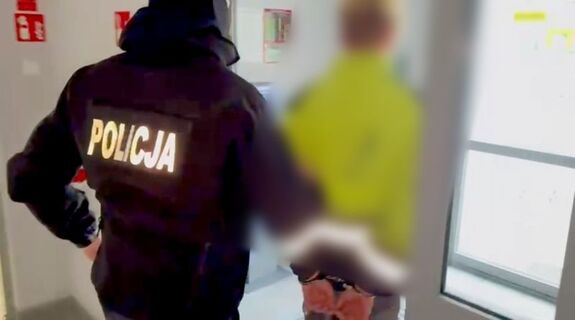 Mężczyzna jest prowadzony przez policjanta
