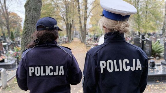 Mapy ze zmianami w organizacji Ruchu oraz policjantki idące w rejonie cmentarza